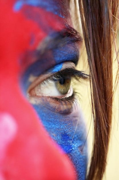 A close-up of a cosplayer's eye painted with Jinx's makeup. The focus is on the smoky eyeshadow, the defined winged eyeliner, and the bright shimmer eyeshadow in the inner corner of the eye. The cosplayer has vibrant blue eyes to match Jinx's appearance.