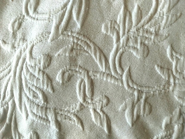 A close-up of Mel Medarda's dress fabric, focusing on the texture, embroidery patterns (if visible), and the specific shades of gold and brown used. This image showcases the luxurious feel of the material and highlights the attention to detail in her costume design.