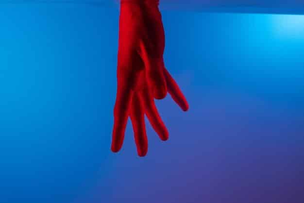 A close-up shot of a cosplayer's hand wearing Sky Young's distinctive glove. The glove features intricate stitching, metallic accents, and glowing LED details, showcasing the attention to detail in the costume.