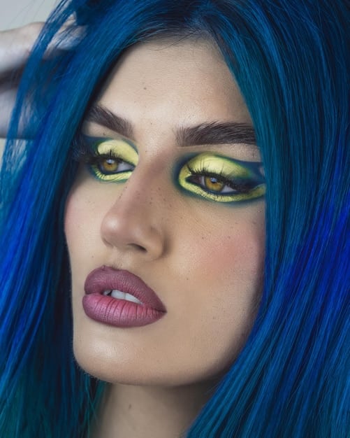 A close-up of a cosplayer's face with Sky Young's signature makeup. The makeup features bold eyeliner, vibrant eyeshadow colors, and subtle contouring, capturing the essence of the character's look.
