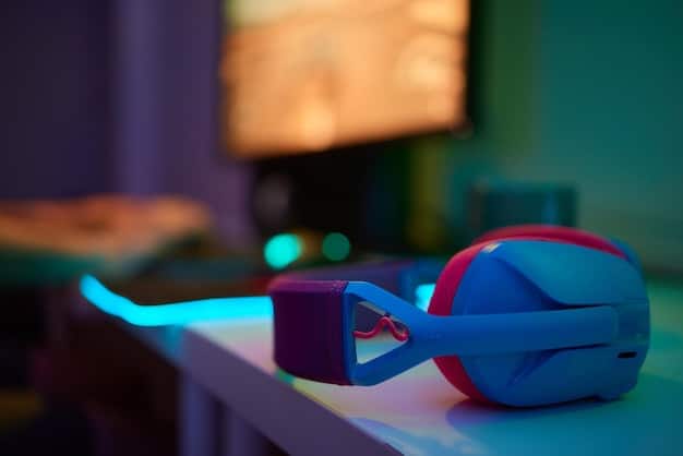 A gaming headset resting on a desk next to a keyboard, illuminated by the glow of a computer monitor displaying a game's title screen.