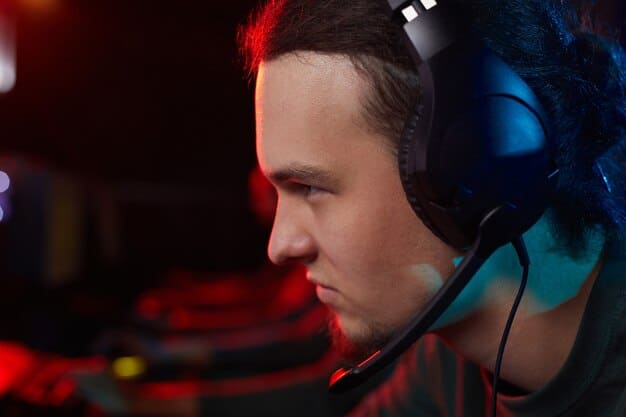 Close-up of a professional gamer wearing a headset, intensely focused on their screen during an esports competition, surrounded by gaming peripherals.