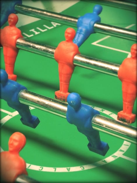 A top-down strategic view of a  match in progress. Two players are building bases and moving their units across a dynamically rendered map. Graphical user interfaces showing resource levels, unit stats, and build queues are visible on the sides of the screen.
