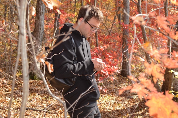 Saga Anderson examining a crime scene in the woods of Bright Falls. The scene is dark and unsettling, with strange symbols carved into the trees. Saga is focused and determined, piecing together the clues to solve the mystery.