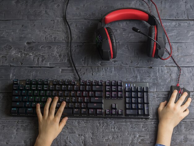 A close-up shot of a playtester's hands on a keyboard and mouse, with a headset on, intensely focused on the game on the screen. The background is blurred, emphasizing the player's immersion in the game and the live feedback being collected.
