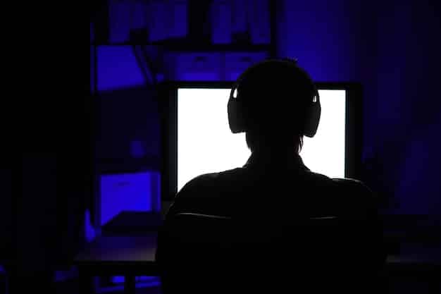 A person silhouetted against a bright computer screen, deeply engrossed in a video game. The glow of the screen illuminates their face, showing intense focus. This visual represents the engagement of a target audience with a video game. The scene is carefully composed to highlight the immersion and appeal of gaming, reinforcing the importance of knowing your audience for effective 'Game Marketing Basics: Promoting Your Game and Reaching Your Target Audience'.