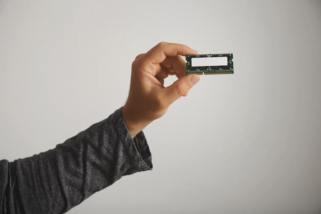 A close-up shot of a hand installing a new RAM stick into a computer motherboard. The lighting highlights the intricate details of the motherboard and the RAM module, emphasizing the precision and care required during the upgrade process. Cables and other components are partially visible, adding context to the scene. The image relates to The Hidden Costs of Upgrading: Avoiding Common Pitfalls and Unexpected Expenses by showing the tangible side of hardware upgrades